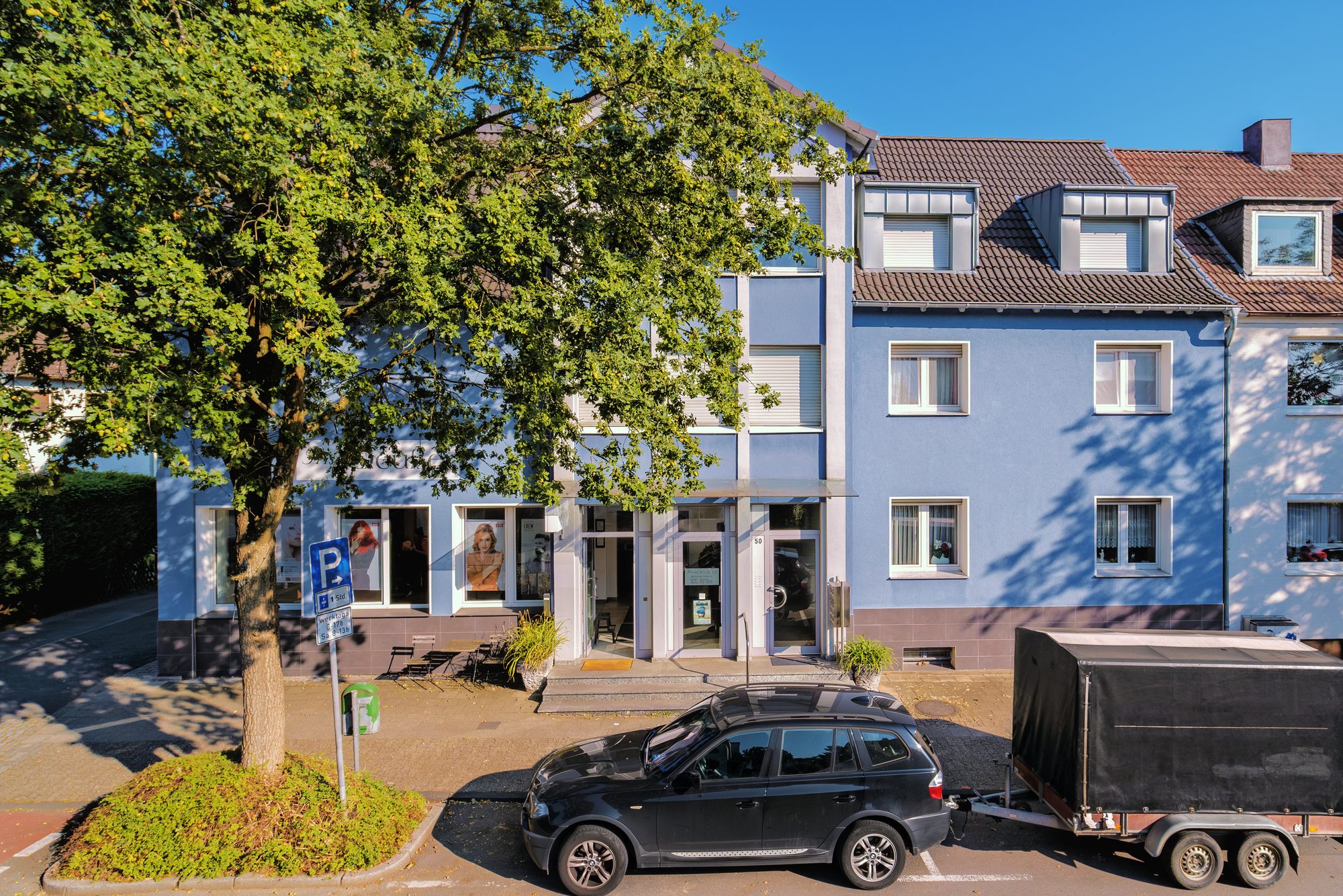 Blaues Wohn- und Geschäftshaus mit Ladenlokal im Erdgeschoss