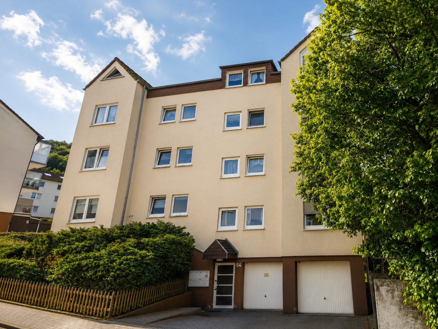 Beiges Mehrfamilienhaus mit Garagenhof