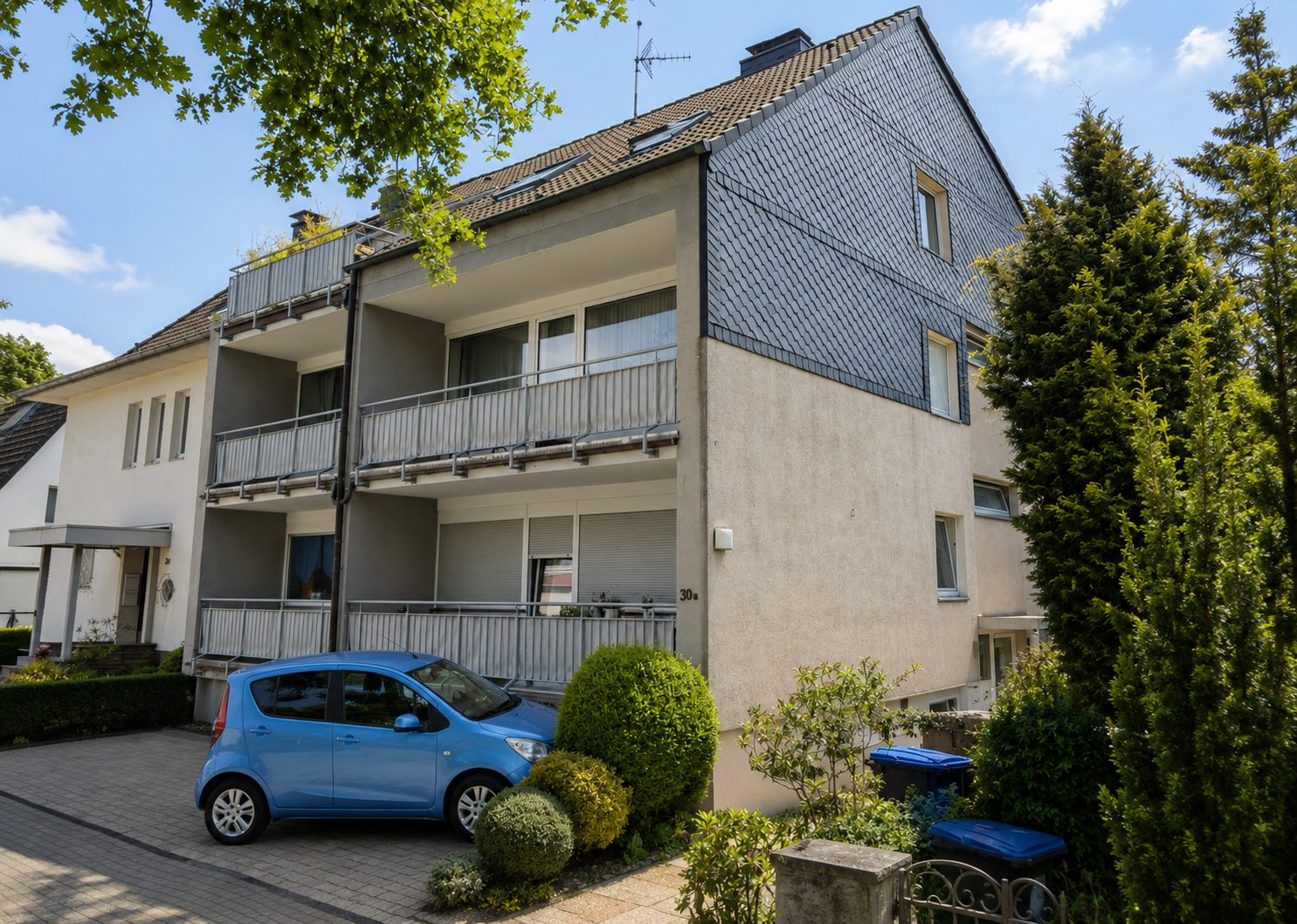 Mehrfamilienhaus mit Schieferfassade und umlaufenden Balkonen