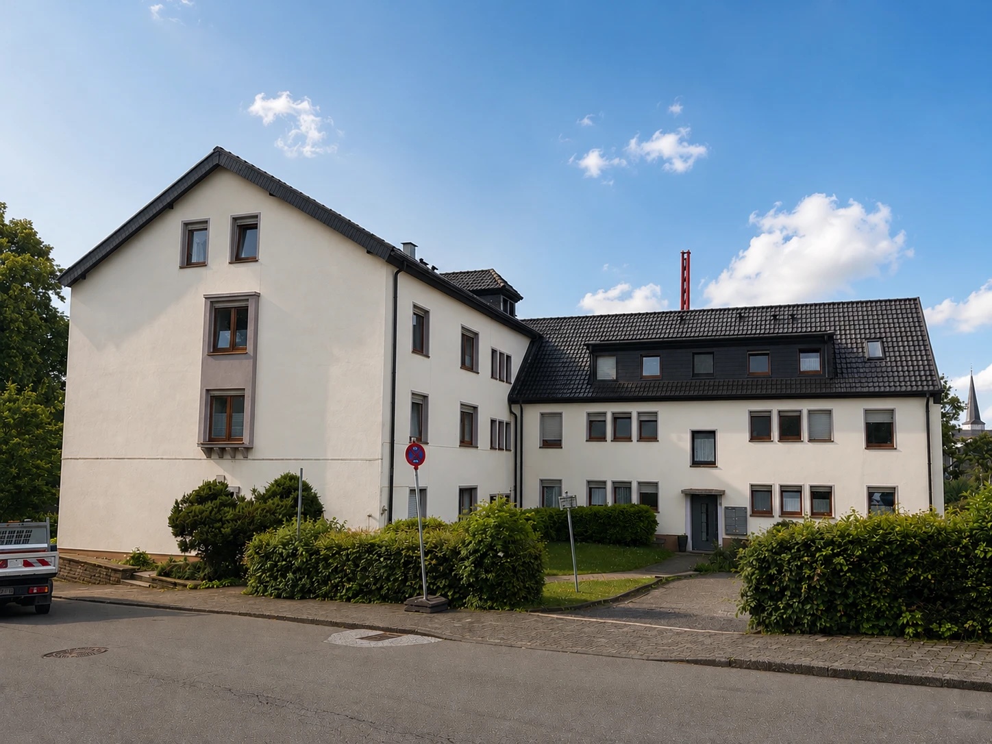 Weiße Wohnanlage mit dunklem Dach